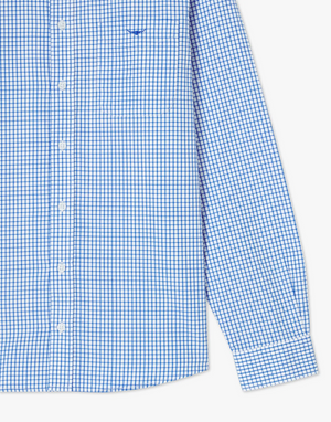 A close-up of the RM Williams Collins Shirt, showcasing its blue and white checkered pattern. This long-sleeved, regular fit button-down features a small embroidered logo on the chest pocket and sleek white buttons down the front. Crafted from twill cotton, both the cuff and lower portion of the sleeve are also visible.