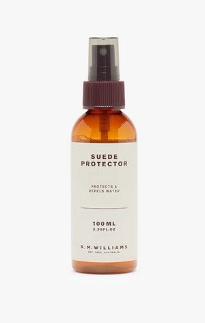 A 100ml spray bottle of RM Williams Suede Protector Spray. The amber-colored bottle comes with a brown spray nozzle and a beige label that reads "Suede Protector - Protects & Repels Water." This product features a non-abrasive formula and has the brand name prominently displayed at the bottom.