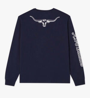 A navy blue RM Williams Signature Long Sleeve T-Shirt adorned with a white graphic of the iconic R.M.Williams Longhorn skull on the upper back. The right sleeve is embellished with the word "COWBOYS" in elegant white cursive lettering running along its length.