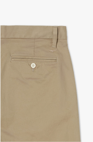 Close-up of the back pocket of the RM Williams Stirling Chino trousers. The pocket features a button closure with a small decorative emblem above it. The waistband includes a belt loop, and the fabric appears to be lightweight, slightly textured, and crafted from stretch cotton for added comfort.