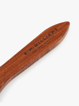 A close-up image of the RM Williams Suede Brass Bristle Brush inscribed with the text "R.M. WILLIAMS, MADE IN AUSTRALIA." The brush has a smooth, polished finish with brass bristles for effective cleaning—perfect for maintaining your suede boots.