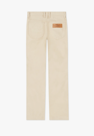 The RM Williams Cleanskin Moleskin Jeans are shown from the back, highlighting their beige color and resemblance to classic moleskin jeans. The pants are designed with two back pockets and a brown leather patch featuring embossed text sewn onto the right pocket. They boast straight legs and belt loops at the waistband, making them a stylish yet rugged choice inspired by Australian stockmen jeans.