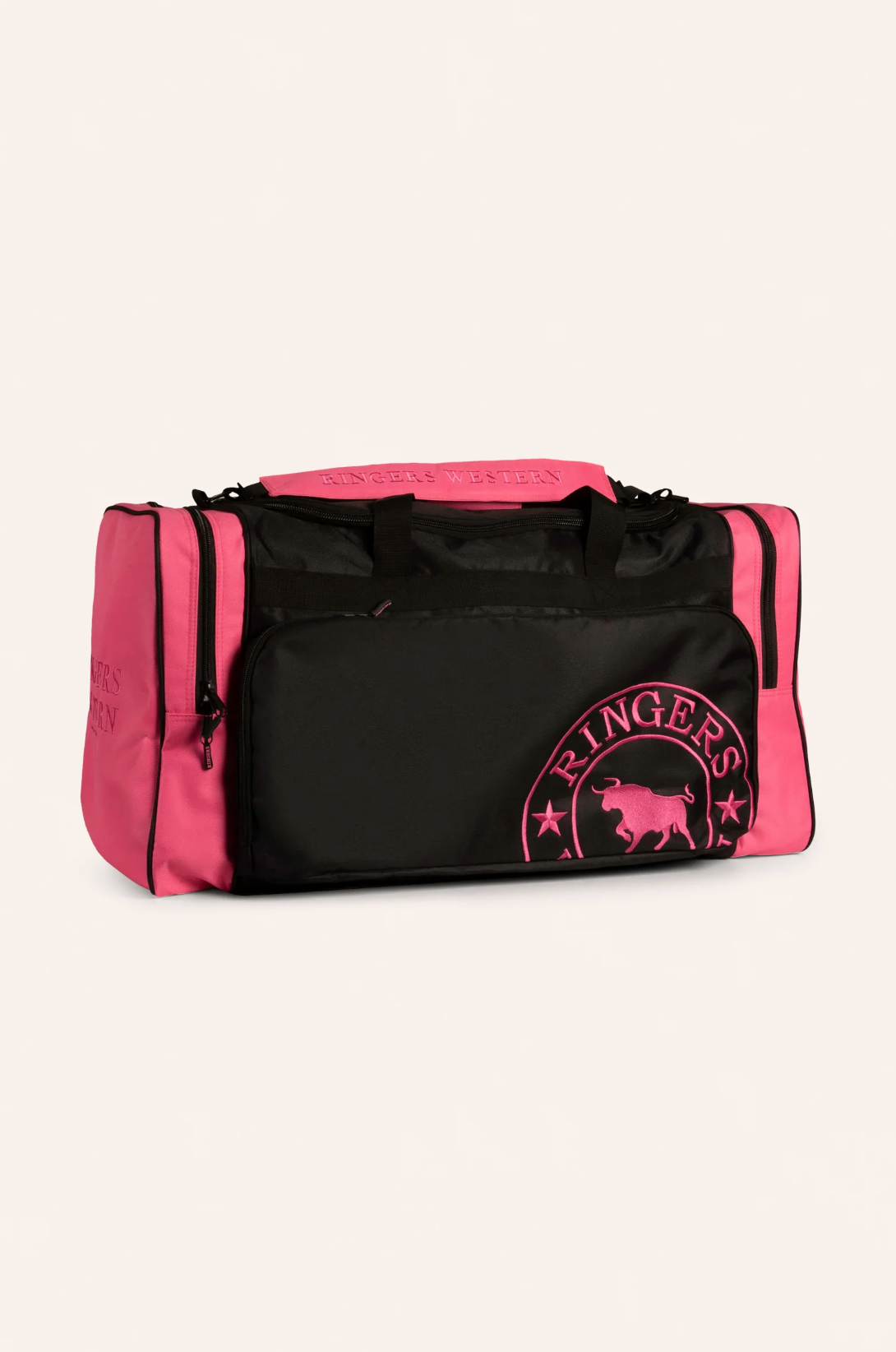 The Ringers Western Rider Sports Bag is a pink and black duffel bag featuring "Ringers Western" on the top handle and side pockets. It boasts multiple compartments, including a large front pocket adorned with a logo that showcases a bull and stars.