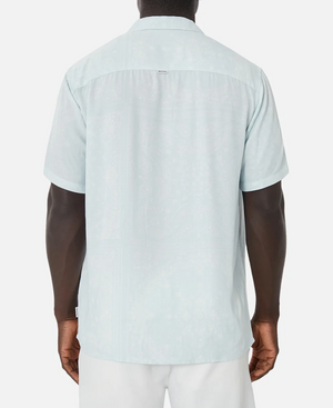 A person is shown from the back wearing the Industrie The Stryder Shirt, a light blue short-sleeve button-down with a subtle paisley pattern. It has a straight hem and relaxed fit, elegantly paired with white pants. The plain white background highlights the outfit effortlessly.