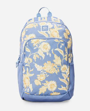 The Rip Curl Ozone 2.0 30L Backpack is made from recycled polyester and features a blue design, large front pocket, adjustable straps, and a yellow floral pattern with various flowers and leaves. The stylish look is completed with a small logo patch on a striped background.