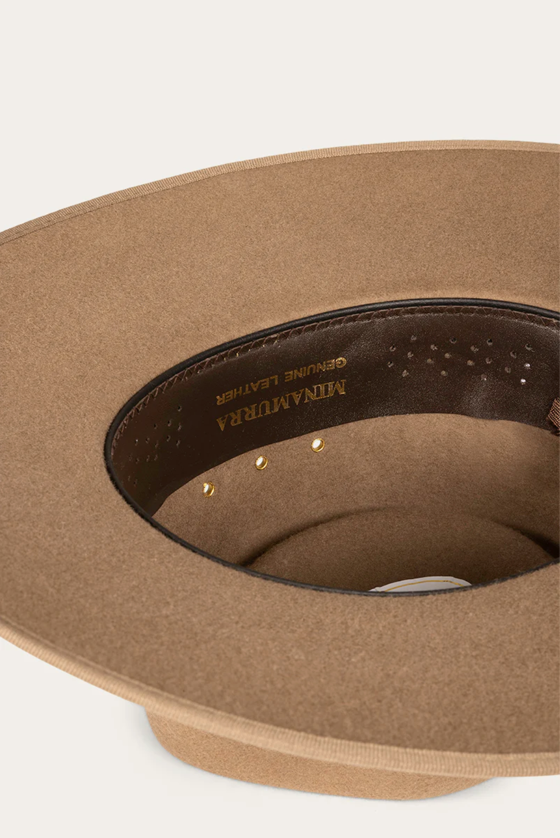 A close-up of the Ringers Western Minamurra Hat's interior shows a "MADE IN U.S.A GENUINE LEATHER" label. A brown hatband with gold rivets enhances its premium felt, showcasing timeless style and expert craftsmanship.