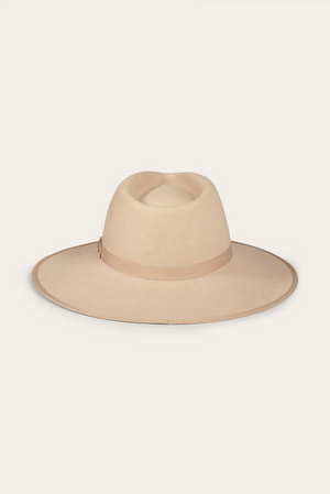 The Ringers Western Woodford Hat is a beige wide-brimmed fedora crafted from premium felt, featuring a matching grosgrain ribbon around the crown, set against a plain background.