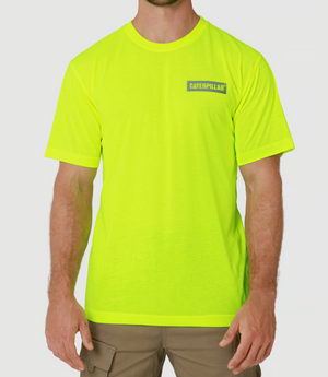 A person is wearing a bright yellow, moisture-wicking CAT Triton Block Tee and brown cargo pants. This 100% cotton T-shirt showcases the Caterpillar logo on the left chest. The background is plain white.