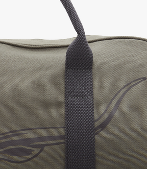 Close-up of the RM Williams Nanga Canvas Bag in gray cotton, showcasing a black abstract design and a black strap with simple weave texture. The top seam of this stylish duffle-style bag is partially visible.