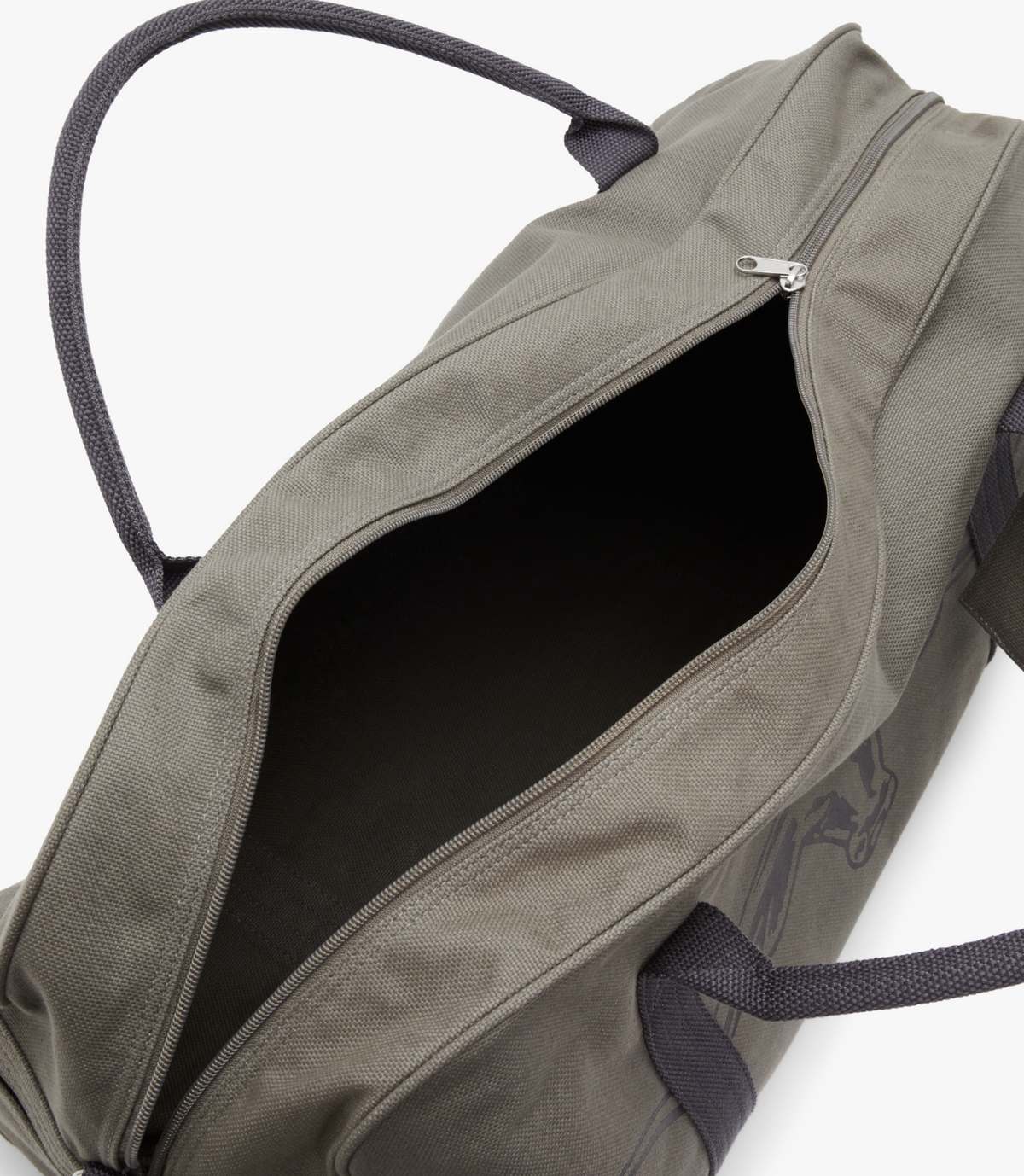 The RM Williams Nanga Canvas Bag is a grey cotton duffel-style bag with black handles, shown on a white background. Its zipper is partially open, exposing a dark, empty interior.