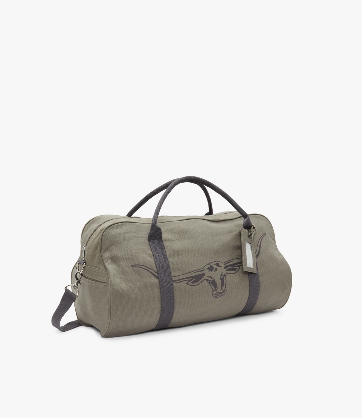 The RM Williams Nanga Canvas Bag is a khaki duffel-style cotton canvas bag with dark handles and strap. It features an embroidered longhorn skull design and has a hanging tag on one handle, set against a plain white background.