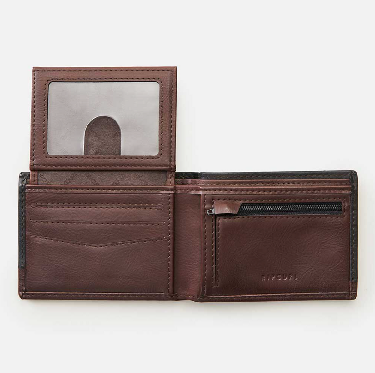 The Rip Curl Ridge PU All Day Wallet, made from rich brown leather with a textured surface, includes multiple card slots, a transparent ID window, and a zippered coin pocket. Laid flat on a white background, it highlights sleek design and functionality.