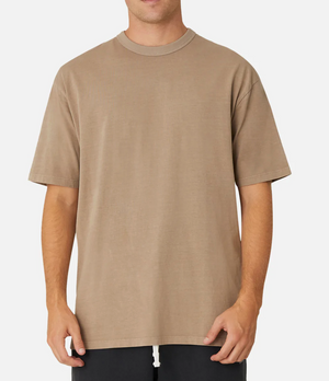 A person wearing the Industrie The Del Sur Tee in plain brown and dark pants stands against a white background, showcasing the relaxed vibe of its oversized fit. The 100% cotton T-shirt reveals only the torso and arms.