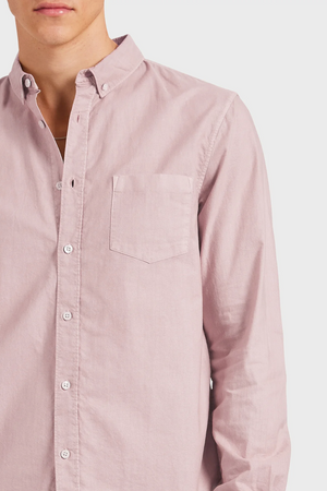 A person wearing the Academy Brand Vintage Oxford Shirt in stylish light pink cotton, featuring a refined point collar and front pocket, shown from shoulders to waist against a plain background.