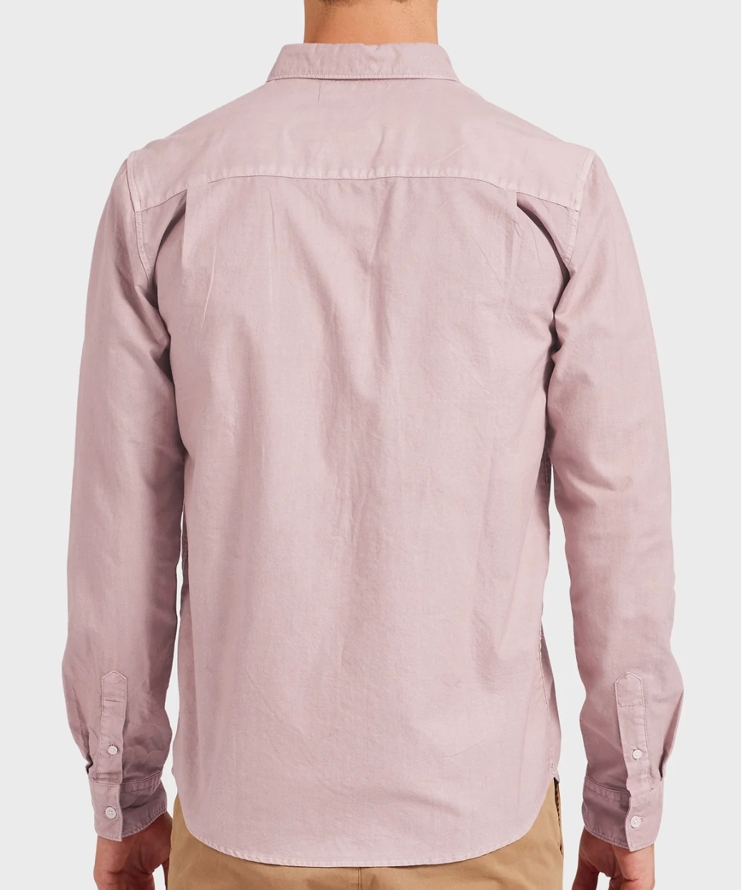 A person is seen from behind wearing an Academy Brand Vintage Oxford Shirt in light pink, featuring long sleeves and a refined point collar, stylishly paired with beige pants against a plain white background.