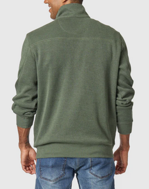 A man is seen from the back, arms relaxed at his sides, wearing the Blazer Heather Half Zip Sweat in green with blue jeans.