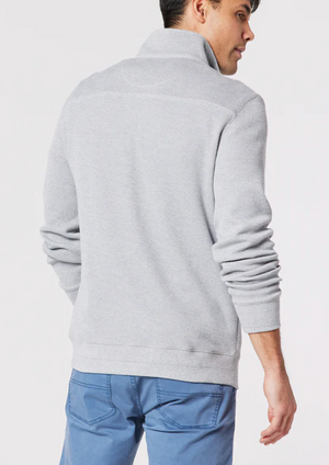 A person is seen from the back wearing a Blazer Heather Half Zip Sweat and blue pants. The sweater features a high collar, with their right arm slightly bent against a plain white background.
