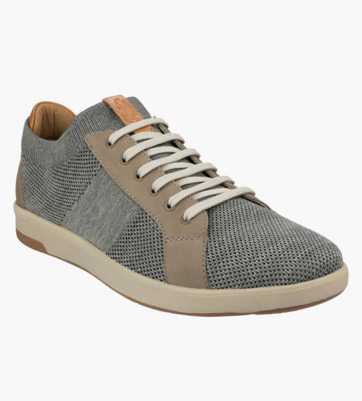 The Florsheim Crossover Knit is a casual sneaker with a grey mesh upper for breathability, suede-like beige overlays, white laces, a beige side stripe, and a light brown rubber sole featuring a cushioned footbed.