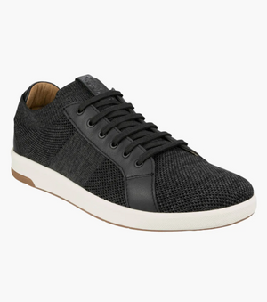 The Florsheim Crossover Knit is a black lace-up sneaker featuring a textured fabric and leather upper, a white rubber sole, and brown inner lining. With a cushioned footbed, it's designed for casual comfort suitable for everyday wear.