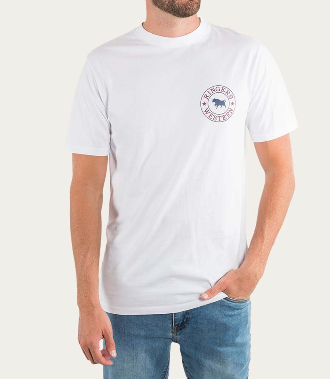 A person is wearing a comfortable Ringers Western Signature Bull Classic T-Shirt, made from pre-shrunk cotton with a small logo of a bull and the text "Ringers Western" on the left chest area. One hand rests in their jeans pocket while the other arm hangs by their side against a plain, light-colored background.