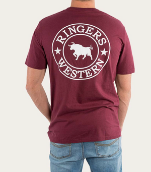 A person is seen from behind wearing a Ringers Western Signature Bull Classic T-Shirt in maroon, featuring short sleeves and a white logo that reads "Ringers Western" with a bull and stars. Made from 100% cotton for comfort and durability, the person pairs this tee with light blue jeans.