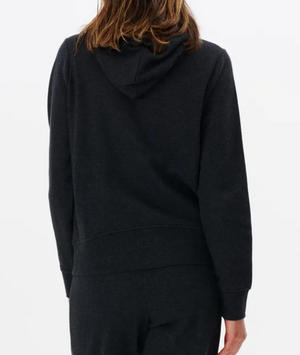 Back view of a person wearing a casual black Rip Curl Script II Hood sweatshirt and matching pants. The person, with brown hair, stands against a white background, comfortably enveloped in the coziness of fleece lining.