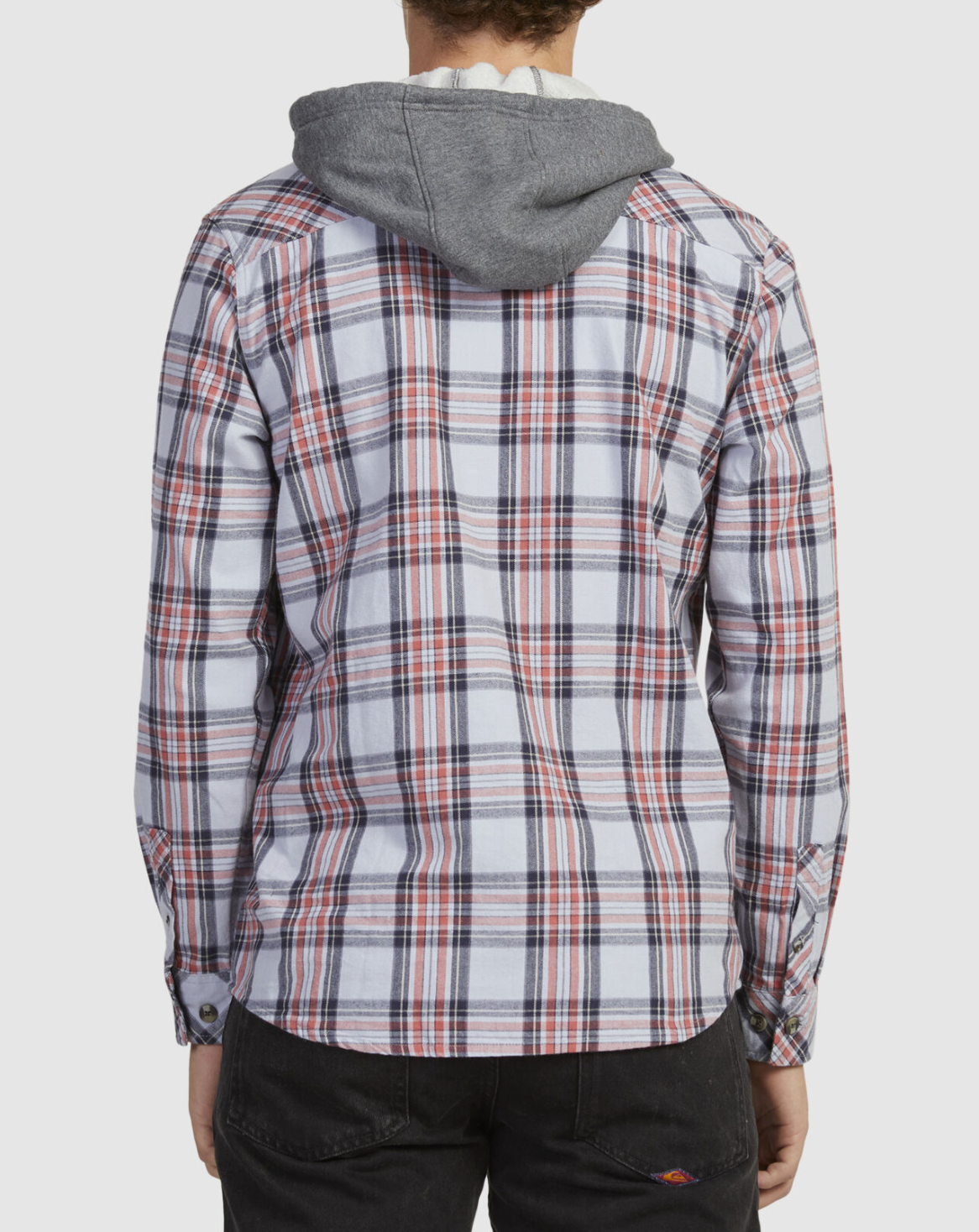 A person wearing a Rip Curl Ranchero Flannel Shirt in red, white, and blue plaid stands back to the camera, paired with dark pants against a plain white backdrop.