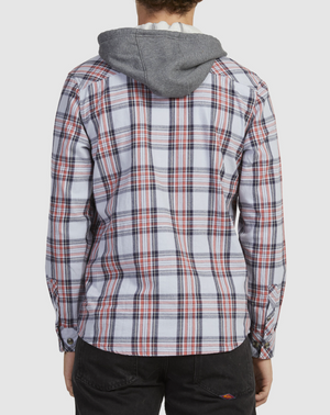 A person wearing a Rip Curl Ranchero Flannel Shirt in red, white, and blue plaid stands back to the camera, paired with dark pants against a plain white backdrop.