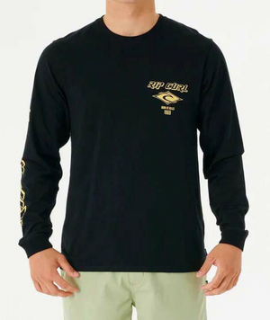A person is wearing a black Rip Curl Fade Out Icon Long Sleeve Tee with yellow lettering on the chest and sleeve, made from organic cotton. This crew neck with small graphics pairs effortlessly with light-colored pants.
