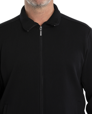 A person wearing the Breakaway Zed Snowy Mt Fleece Full Zip in sleek black, a cotton-polyester blend with a neat collar and zipper halfway up. Sporting a short beard, they're shown from shoulders up against a plain white background, exuding understated style and comfort.