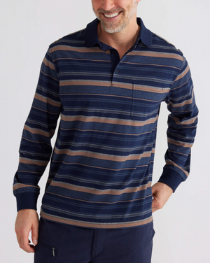 A man beams as he wears the Breakaway Wallux Kinnersly Jersey Polo, a relaxed-fit long-sleeve shirt in navy blue and brown stripes, against a plain white background.