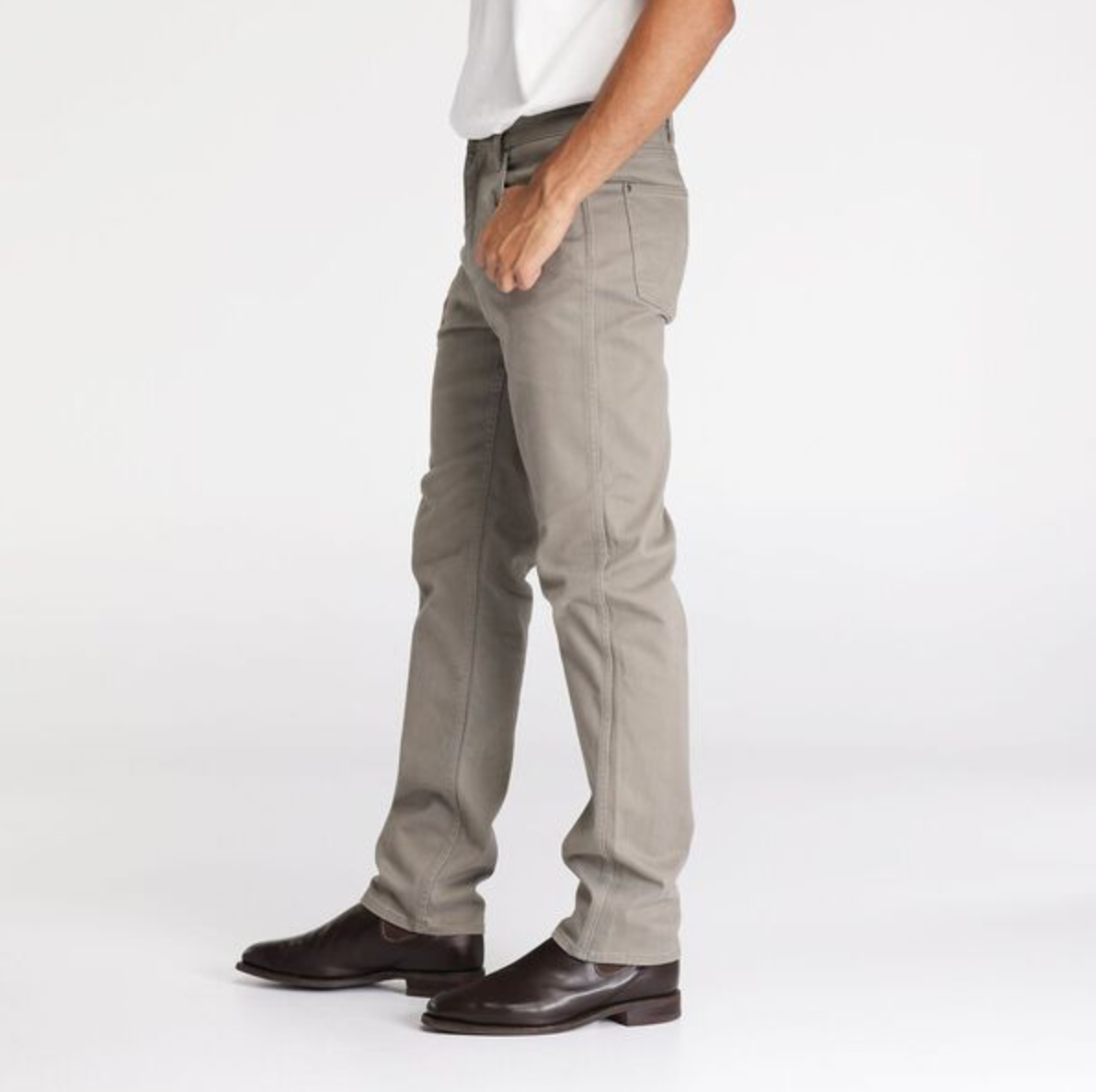 A person stands in a side pose wearing Wrangler Classics Straight Moleskin Jeans, a white shirt, and brown leather shoes against a plain white background.