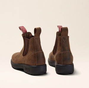 Two Rossi Endura 303 brown full grain leather ankle boots, with black slip-resistant soles and a red pull tab with white text, are shown from the back against a beige background.