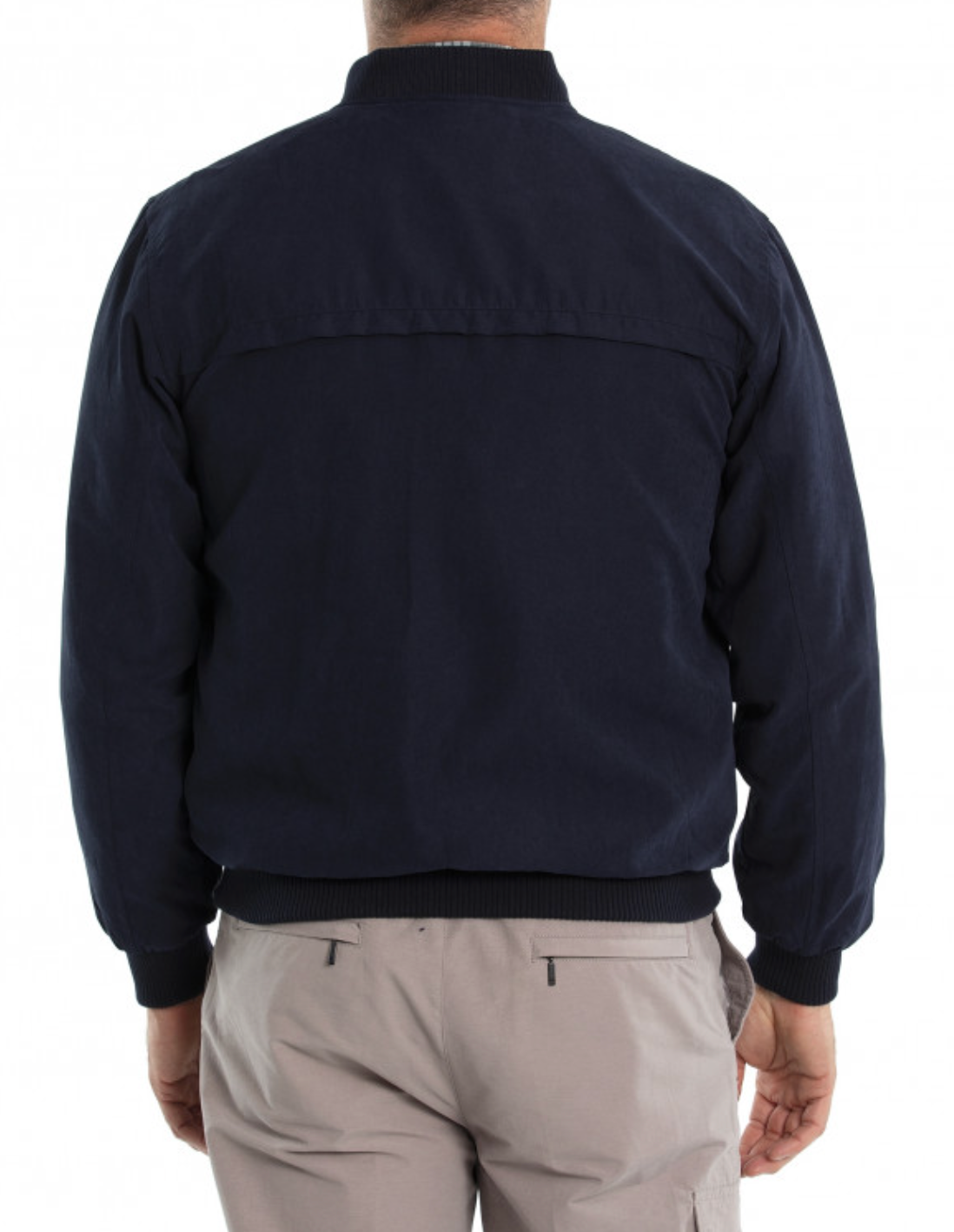 A person is shown from the back, wearing the Breakaway Microfibre Bomber Jacket in dark navy, featuring a rib knit collar, full zip front, and horizontal shoulder seam. They pair it perfectly with beige pants with front pockets for a casual yet stylish look.