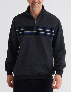 A man stands smiling against a white background, wearing the Breakaway Bello Snowy Mt Fleece Half Zip in dark gray with light gray, white, and blue stripes. The fleece offers comfort to his relaxed look as his hands rest by his sides.