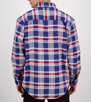 A person with short hair wears a shirt from the Swanndri Egmont Flannelette Twin Pack, featuring a soft brushed cotton plaid pattern in blue, red, and white against a plain background.