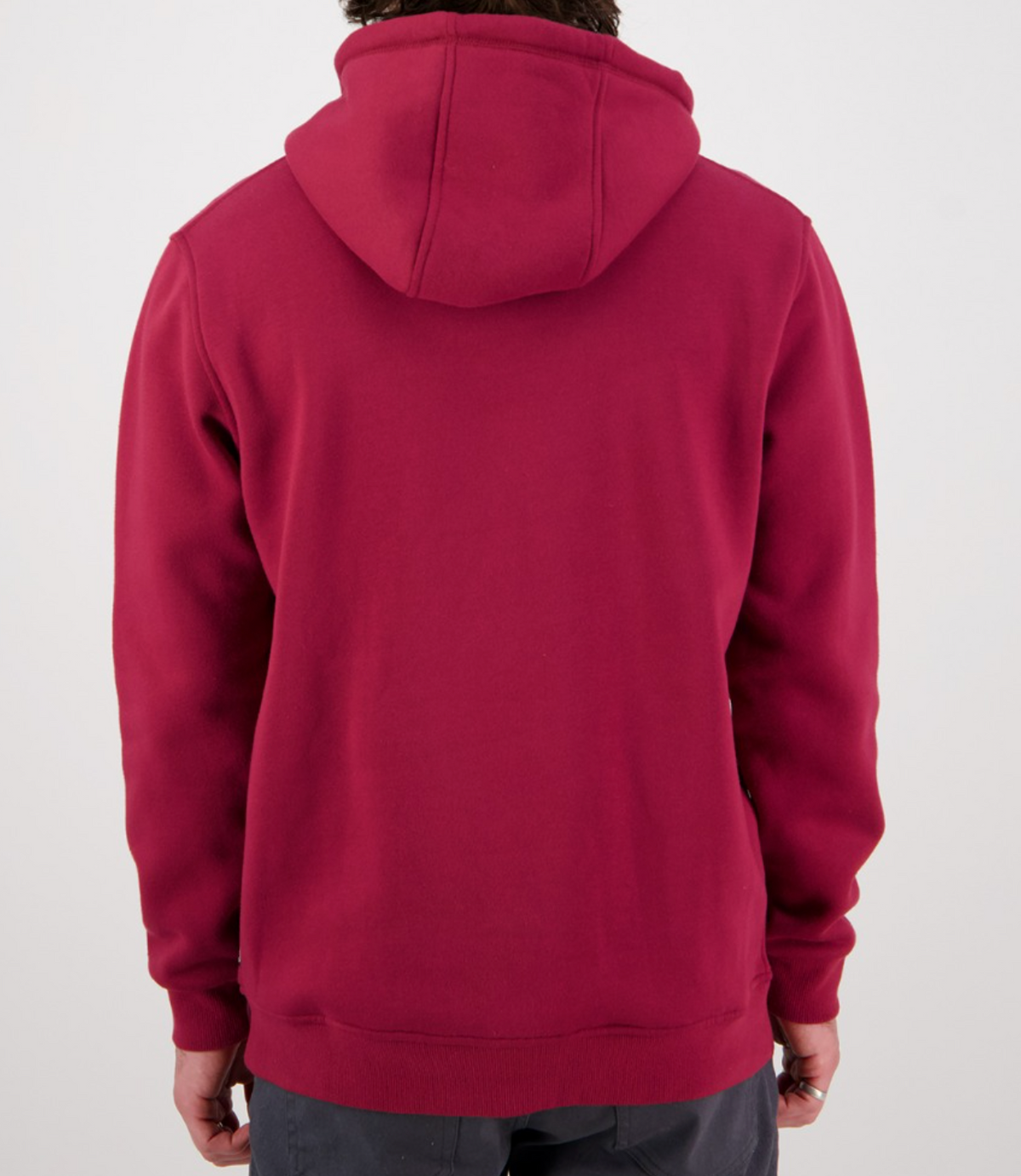 The image shows a person wearing the Swanndri Original Fleece Hoody in maroon, creating a casual vibe with the hood down as they face away from the camera. The long sleeves hang by their sides, perfectly matching their dark pants for an effortlessly relaxed look.