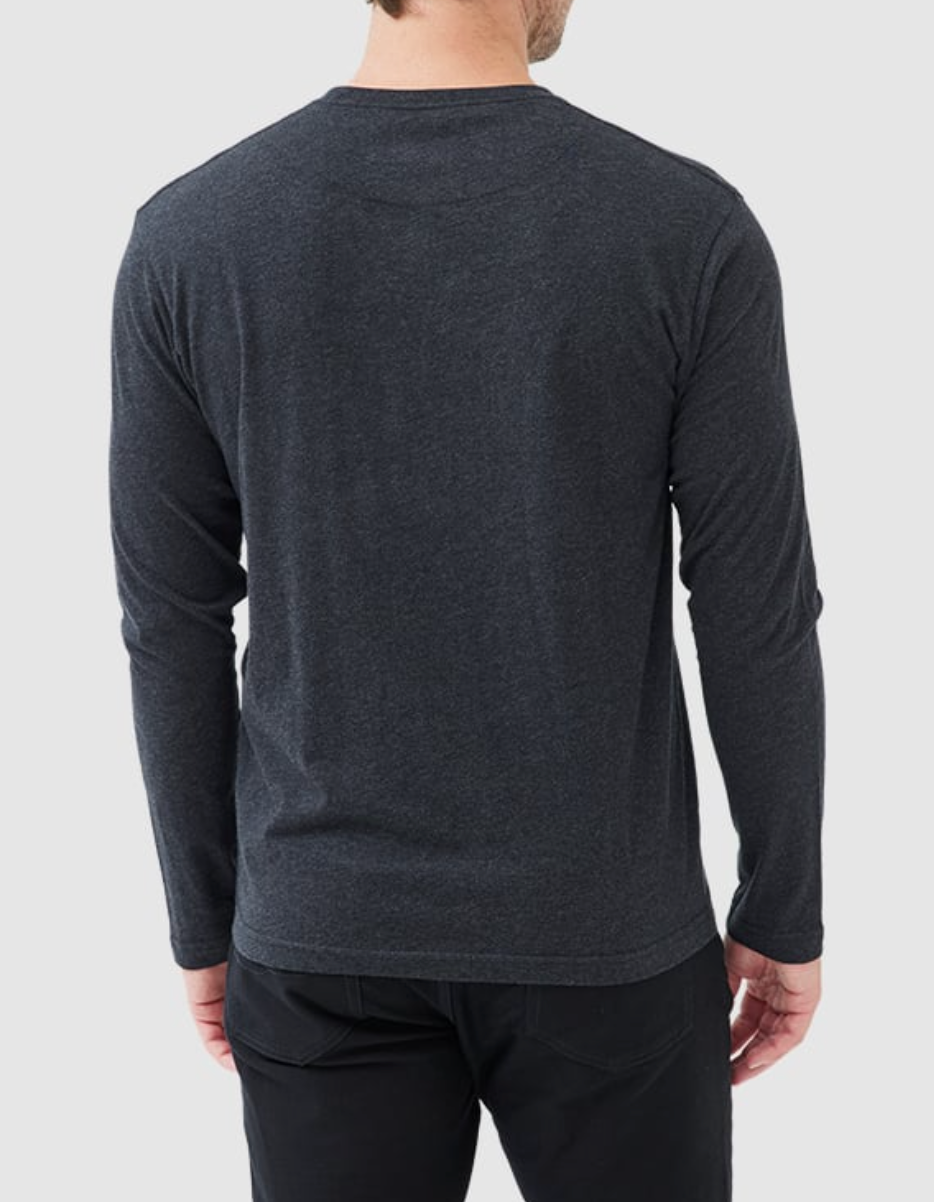 A person in a dark gray Rodd & Gunn Long Sleeve Gunn T-Shirt, made of 100% cotton, and black pants faces away from the camera against a light gray background. The sports fit adds a relaxed vibe, ideal for casual settings.