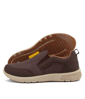 The Colorado Saka Casual Shoe features brown slip-ons with a textured fabric upper and tan soles. One shoe stands upright while the other rests on its side, showcasing the tread pattern. The heel subtly displays branding, complemented by arch support and a small back loop.