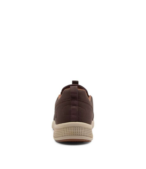 The Colorado Saka Casual Shoe is shown from the back, featuring a textured tan rubber sole and a handy heel pull tab. Its sleek, slip-on design with subtle stitching combines style and practicality against a plain white background.
