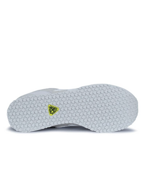 The New Balance 515 SR Shoe features a slip-resistant rubber outsole with a hexagonal tread pattern. It's light gray with a yellow and black triangular logo at the center of the sole, showcased flat on a pristine white background.