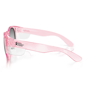 Side view of SafeStyle Cruisers with pink frames and tinted lenses, featuring engraved text and a small black and pink breast cancer awareness ribbon. The glossy, lightweight design offers UV protection, combining style with essential safety.