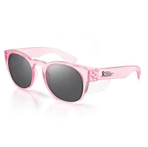 SafeStyle Cruisers feature pink plastic frames with glossy, semi-transparent finish and tinted UV-protective lenses. The temples display a black National Breast Cancer Foundation ribbon logo and text, combining style with safety ratings.