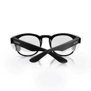 A pair of SafeStyle Cruisers Black Frame Clear Lens safety glasses with crossed arms, clear UV-protective lenses, and branding on both temples, displayed against a white background.