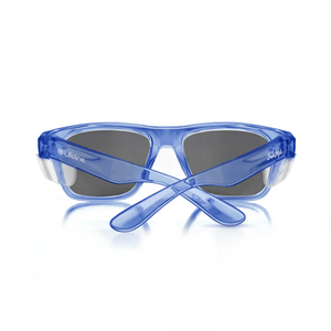 The SafeStyle Fusions sunglasses feature blue semi-transparent frames, tinted lenses, and wide arms. Brand logos on the temples are visible, and they provide UV protection. Displayed upright on a white surface, their sleek design is evident from the back view.