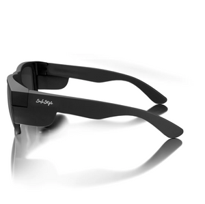 The SafeStyle Fusions Matte Black Frame Polarised Lens sunglasses feature thick frames and UV protection. Displayed from a back-side angle, the brand name appears in white on the arms, and they are placed on a glossy surface casting a subtle reflection.