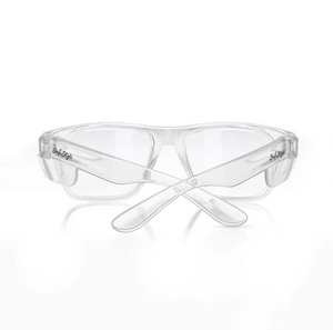 The SafeStyle Fusions clear eyeglasses feature a logo on the temples. Designed for safety, the transparent polycarbonate frames and lenses offer UV protection. The earpieces cross underneath, shown from the back angle.