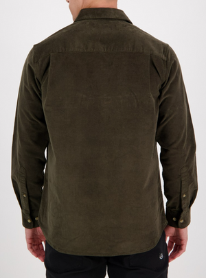 A person wears the Swanndri Ranfurly Corduroy Shirt in tailored fit, dark green, featuring buttoned cuffs. Paired with black pants, this heavyweight cotton outfit is set against a plain white background, capturing their back to the camera.