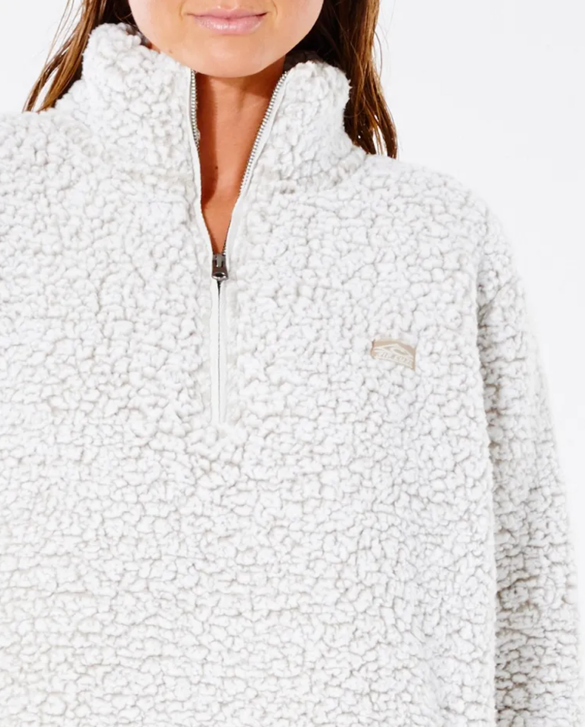 A woman wears a Rip Curl Dark N Stormy 1/4 Zip Crew sherpa fleece jumper featuring a small embroidered chest logo, set against a plain white background.
