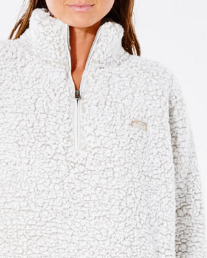 A woman wears a Rip Curl Dark N Stormy 1/4 Zip Crew sherpa fleece jumper featuring a small embroidered chest logo, set against a plain white background.